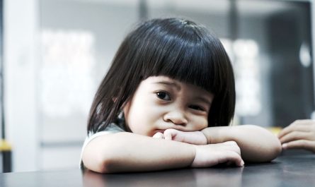 Petite fille brune aux cheveux droits et au visage rond, les coud