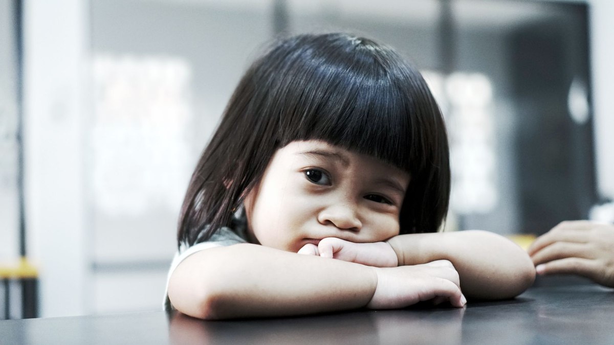 Petite fille brune aux cheveux droits et au visage rond, les coud