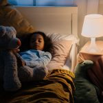 Une fillette dort paisiblement dans son lit avec son doudou