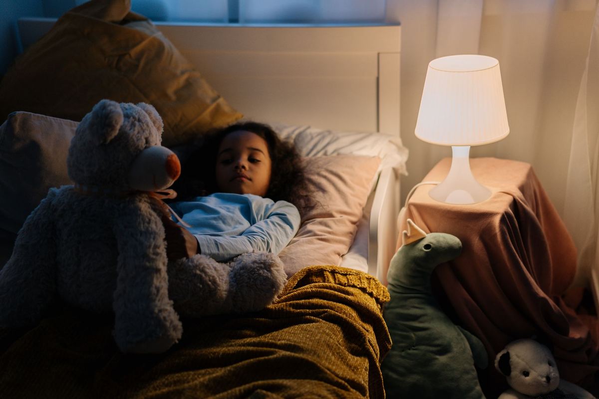 Une fillette dort paisiblement dans son lit avec son doudou
